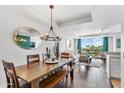 Well-lit dining area with a modern chandelier, wooden table with bench, and views of the living room at 6803 E Main St # 5503, Scottsdale, AZ 85251