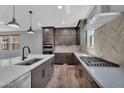 Gourmet kitchen featuring stainless steel appliances and a sleek cooktop with quartz countertops at 687 W Flintlock Way, Chandler, AZ 85286
