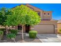 Inviting two-story home with a two-car garage, mature landscaping, and a welcoming front entryway at 8879 W Cameron Dr, Peoria, AZ 85345