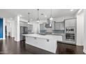 Modern kitchen with stainless steel appliances, a large island, and beautiful backsplash at 9936 E Revolution Dr, Mesa, AZ 85212