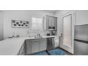Cozy kitchenette with stainless steel appliances, white cabinets, and quartz countertops at 9936 E Revolution Dr, Mesa, AZ 85212