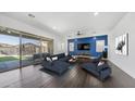 Bright living room with a blue accent wall, sleek furniture, and sliding glass doors to the backyard at 9936 E Revolution Dr, Mesa, AZ 85212