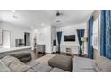 Bright living room features a modern ceiling fan, neutral paint, and contemporary decor at 9936 E Revolution Dr, Mesa, AZ 85212