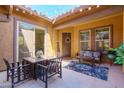 A cozy covered patio with a dining set, comfortable seating, decor, and string lights at 10402 E Starion Ave, Mesa, AZ 85212