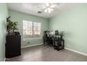 Bright bedroom with a ceiling fan, a large window with blinds, and tile flooring at 11473 W Austin Thomas Dr, Surprise, AZ 85378
