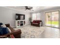 Cozy living room with sliding glass doors, tile floors, and modern furnishings at 11473 W Austin Thomas Dr, Surprise, AZ 85378
