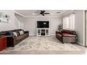 Comfortable living room with tile floors, ceiling fan, and staircase access at 11473 W Austin Thomas Dr, Surprise, AZ 85378