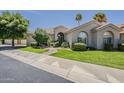 Charming home exterior features a well-maintained lawn, mature trees and inviting curb appeal at 11675 E Caron St, Scottsdale, AZ 85259