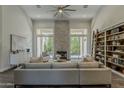 Bright living room with fireplace, high ceilings, and large windows bringing the outside in at 11675 E Caron St, Scottsdale, AZ 85259