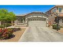 Single-story home with desert landscaping, basketball hoop, and a two-car garage at 12416 W Midway Ave, Glendale, AZ 85307