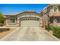 A beautiful single-story house features a beige two-car garage and a basketball hoop at 12416 W Midway Ave, Glendale, AZ 85307