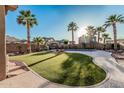 Lush backyard with artificial turf, palm trees, and a sparkling pool perfect for outdoor relaxation at 13446 S 186Th Ave, Goodyear, AZ 85338