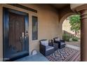Cozy front porch with decorative door, comfortable seating area, and a colorful outdoor rug at 13446 S 186Th Ave, Goodyear, AZ 85338