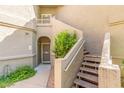 Beige stucco exterior with arched doorway and staircase leading to the upper level at 15252 N 100Th St # 1156, Scottsdale, AZ 85260