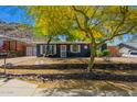 Charming home with landscaped yard, rock retaining wall, and a welcoming entrance, set against a desert mountain landscape at 1527 E Sunnyslope Ln, Phoenix, AZ 85020