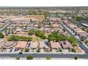 Aerial view of a sprawling neighborhood with mature trees and desert landscape in the background at 15704 W Taylor St, Goodyear, AZ 85338