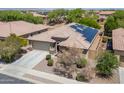 Single-story house featuring solar panels, desert landscaping, and a two-car garage at 15704 W Taylor St, Goodyear, AZ 85338