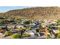 Stunning aerial view of a peaceful neighborhood nestled against a mountain with lush green trees and blue skies at 1644 W Thunderbird Rd, Phoenix, AZ 85023