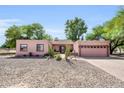 Charming single-story home featuring desert landscaping and a two-car garage for convenient parking at 17705 E Canyon Way, Gilbert, AZ 85298