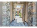 Inviting front entrance with stone archway, decorative metal gate, and paver walkway at 1805 W Dusty Wren Dr, Phoenix, AZ 85085