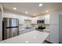 This bright kitchen features white cabinets, a stainless steel fridge, and a stainless steel stove at 18202 N Cave Creek Rd # 122, Phoenix, AZ 85032