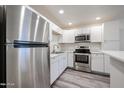 Bright kitchen featuring stainless steel appliances, white cabinets, and sleek countertops at 18202 N Cave Creek Rd # 122, Phoenix, AZ 85032