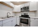 This kitchen features stainless steel appliances, white cabinets, and granite countertops at 18202 N Cave Creek Rd # 122, Phoenix, AZ 85032