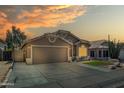 Inviting front exterior view of the home with a two car garage and lovely desert landscaping at sunset at 18845 N 23Rd Pl, Phoenix, AZ 85024