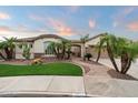 Inviting desert home with mature palms, well manicured lawn, and a stone facade at 19902 S 190Th St, Queen Creek, AZ 85142