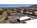 Expansive aerial view of the neighborhood featuring lush green spaces, community park, and mountain views at 2070 E Saddlebrook Ct, Gilbert, AZ 85298