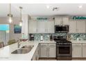 Modern kitchen featuring white countertops, stainless steel appliances, and stylish pendant lighting at 2070 E Saddlebrook Ct, Gilbert, AZ 85298