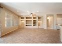 Spacious living room with tile flooring, built-in shelving and niches, and a ceiling fan at 20900 N Vista Trl, Surprise, AZ 85387
