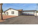 Home exterior featuring a carport with a gate, stucco walls, and desert landscaping at 22312 W Hammond Dr, Buckeye, AZ 85326