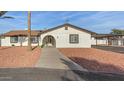 Classic home exterior featuring an arched entryway, neutral paint, and well-kept yard at 22312 W Hammond Dr, Buckeye, AZ 85326