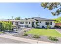 Beautiful single-story home with a patio sitting area, manicured lawn, and white exterior paint at 3029 E Elm St, Phoenix, AZ 85016