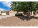 This single-Gathering home features a two-car garage, desert landscaping, and a mature shade tree at 30587 N Maple Chase Dr, San Tan Valley, AZ 85143