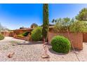 Well-maintained front yard of a single-story brick home, highlighted by lush shrubs and a neat, gravel landscape at 3131 E Las Rocas Dr, Phoenix, AZ 85028
