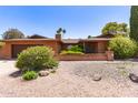 Single-story brick home with well-kept landscaping, a two-car garage, and a welcoming front yard at 3131 E Las Rocas Dr, Phoenix, AZ 85028