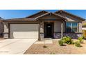 Attractive home exterior boasting stone accents, a covered entry, and a convenient two-car garage for ample parking at 4034 W Nora Dr, San Tan Valley, AZ 85144