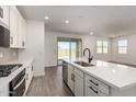 Bright kitchen with white cabinets, quartz countertops, stainless appliances, and an open floorplan with access to the patio at 4034 W Nora Dr, San Tan Valley, AZ 85144
