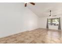 Bright living room featuring tile floors, ceiling fan, and a window with curtains that let in natural light at 4107 W Campo Bello Dr, Glendale, AZ 85308