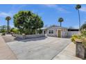 Charming home exterior with lush green trees, side yard, and large driveway at 4216 N 20Th St, Phoenix, AZ 85016
