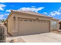 Home featuring a tile roof, tan stucco, two-car garage with low maintenance landscaping at 4387 E Hartford Ave, Phoenix, AZ 85032