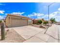 Street view featuring a tile roof, tan stucco, a two-car garage, and desert landscaping at 4387 E Hartford Ave, Phoenix, AZ 85032
