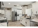 Bright kitchen featuring white cabinetry, stainless steel appliances, and wood-look flooring at 5320 E Thomas Rd, Phoenix, AZ 85018