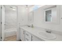 Bright bathroom featuring double sinks, quartz counters, framed mirrors, and tub-shower combo with marble surround at 610 E Montebello Ave # 46, Phoenix, AZ 85012