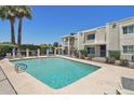 Community pool area featuring a pool, lounge chairs, privacy fence, and mature trees at 610 E Montebello Ave # 46, Phoenix, AZ 85012