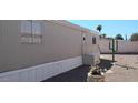 Charming manufactured home with desert landscaping, vibrant pink flamingo, and bright blue sky at 730 S Country Club Dr # 81, Mesa, AZ 85210