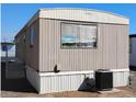 Well-maintained manufactured home showcasing an efficient AC unit and accessible steps to the entrance at 730 S Country Club Dr # 81, Mesa, AZ 85210