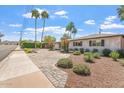 Inviting front yard featuring lush landscaping, a brick driveway, and a well-maintained white brick home at 735 E Northern Ave, Phoenix, AZ 85020